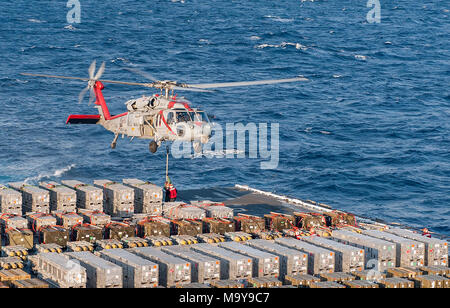 180326-N-JC 445-0101 ATLANTIK (26. März 2018) Segler Haken ordnance zu einem MH-60S Sea Hawk, Hubschrauber Meer Combat Squadron (HSC) 9, während einer Munition Off-load an Bord der Flugzeugträger USS George H.W. befestigt Bush (CVN 77). Das Schiff ist im Gange, die Erhaltung übungen Träger bereit zu halten. (U.S. Marine Foto von Mass Communication Specialist 3. Klasse Mario Coto) Stockfoto