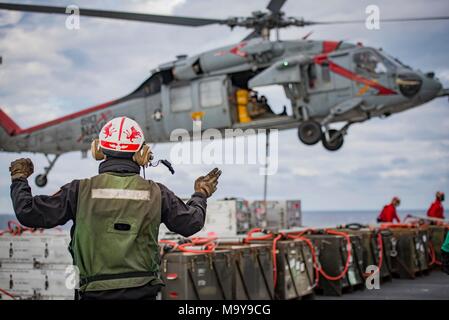 180326-N-SO 730-0099 (26. März 2018) Aviation Elektriker Mate's 3.Klasse Jakob Howell, von Sarasota, Florida, zu Hubschrauber Meer Combat Squadron 9 zugeordnet, leitet eine von seinem geschwader MH-60S Sea Hawk Hubschrauber während eines Munition offload an Bord der Flugzeugträger USS George H.W. Bush (CVN 77). Das Schiff ist im Gange, die Erhaltung übungen Träger bereit zu halten. (U.S. Marine Foto von Mass Communication Specialist 3. Klasse Joe Boggio). Stockfoto