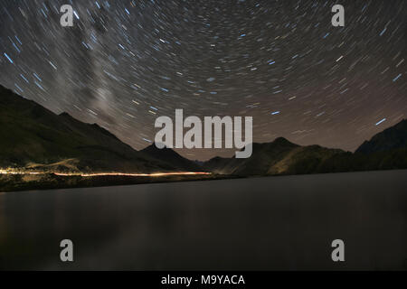 Star trails und die Milchstraße über Moke Lake in der Nähe von Queenstown, Neuseeland Stockfoto