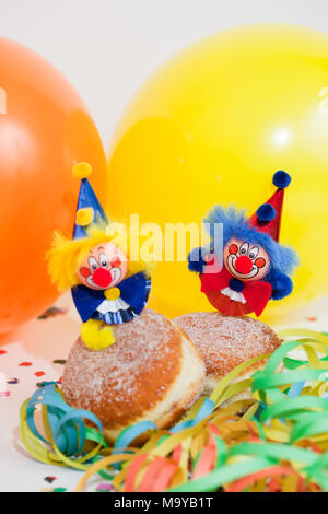 Krapfen oder Krapfen mit Clowns, Luftschlangen und Ballons Stockfoto