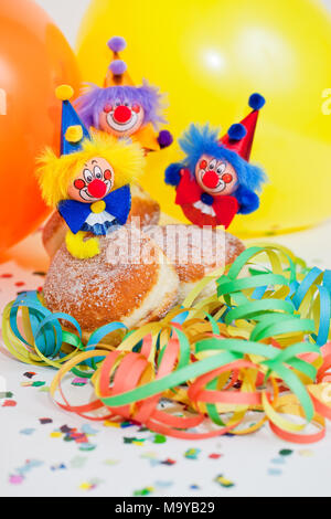 Krapfen oder Krapfen mit Clowns, Luftschlangen und Ballons Stockfoto