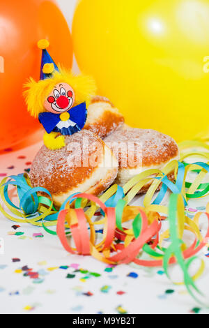 Krapfen oder Krapfen mit Clowns, Luftschlangen und Ballons Stockfoto