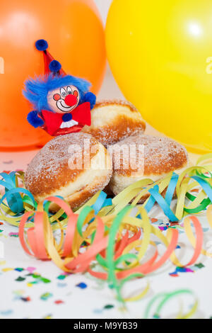 Krapfen oder Krapfen mit Clowns, Luftschlangen und Ballons Stockfoto