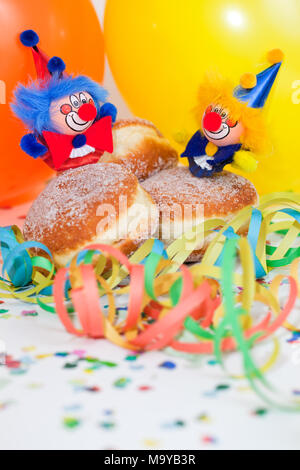 Krapfen oder Krapfen mit Clowns, Luftschlangen und Ballons Stockfoto