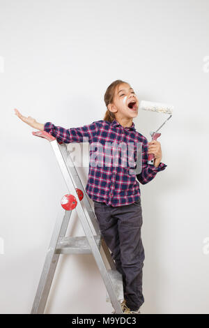 Jugendlich Mädchen Maler mit einem Pinsel auf die weiße Wand im Haus. Reparatur zu Hause Stockfoto