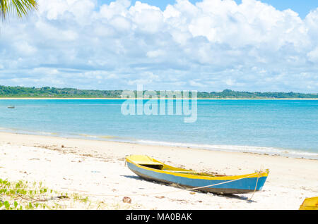 Gelb und Blau Kanu Stop auf der Sand am Strand. Hintergrund Mit der klare Himmel an einem sonnigen Tag und einen schönen blauen Meer. Stockfoto