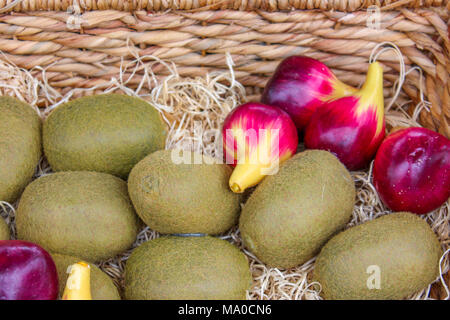 Kiwi und Zwiebeln in einem Korb, Obst und Gemüse in einem Käfig Stockfoto