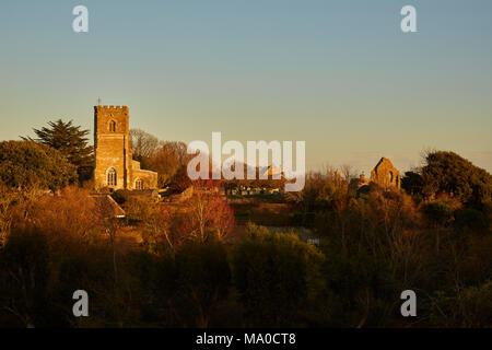 Kirche St. Nikolaus, Abbotsbury Abtei und die Bäume und die umliegenden Landschaft mit einem Winter Sonnenuntergang gemalt. Dorset, England, Großbritannien Stockfoto
