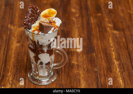 Eis Schokolade Cocktail in Glas mit Sirup, Banane, Süßigkeiten und andere Leckereien, Nahaufnahme Stockfoto