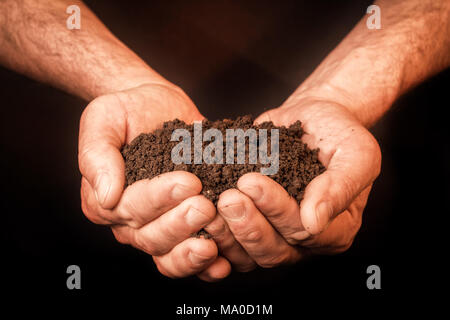 Handvoll Erde in den Händen Stockfoto