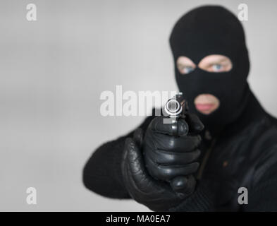 Portrait von bewaffneten Mann in Balaclava im Innenbereich. Platz für Text. Stockfoto