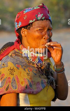 Buschmann (San) Frau rauchen Zigarette in die Kalahari Wüste in Ghanzi, Botswana. Stockfoto