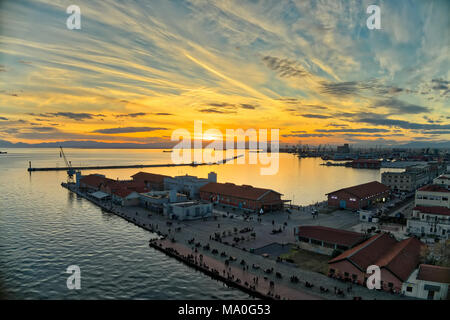 Explosion der Farben vom Sonnenuntergang über dem Hafen in der Stadt Thessaloniki, Griechenland Stockfoto