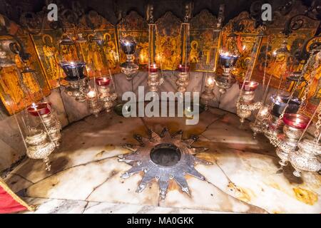 Ein silberner Stern markiert den traditionellen Ort der Geburt Jesu in einer Grotte unterhalb der Geburtskirche in Bethlehem, Palästina. Stockfoto