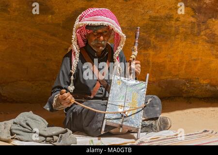Alte Rebab Bedouin Spieler mit seiner selbst gemacht Instrument Gesang in der Wüste Petra, Jordanien. Stockfoto