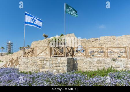 Antike Überreste von ceasarea und wehende Flagge Israels in Maritima Nationalpark in Caesarea, Israel. Stockfoto