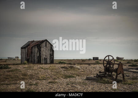 Eine verrostete alte Stück von Maschinen in der Nähe eines alten, verlassenen Hütte auf der Kiesstrand in Dungeness in Kent Stockfoto