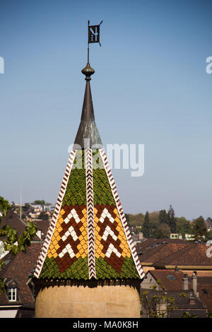 Turm mit bunten Kacheln an der Garten der Stiftskirche in Neuchâtel in der Schweiz Stockfoto