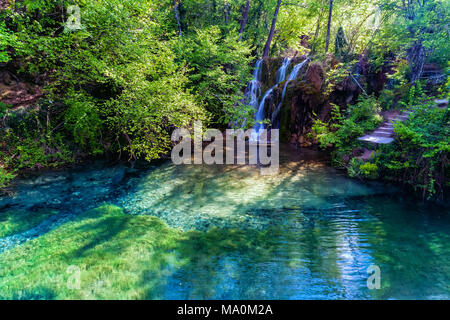 Schönen Wasserfall und einem kleinen See mit grünen Wasser in den grünen Wald in Skra in Nord Griechenland Stockfoto