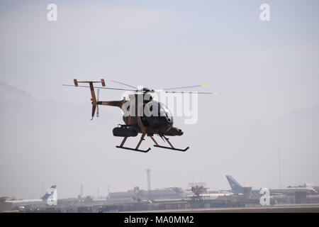 Ein MD 530F Cayuse Krieger leichte Kampfhubschrauber der Afghanischen Luftwaffe über den Asphalt von Kabul militärischer Flughafen fliegen. Stockfoto