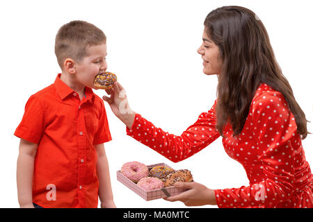 Baby Kleinkind süße Krapfen essen. Eine Frau ist die Fütterung ein Baby mit einem donut. isolieren Stockfoto