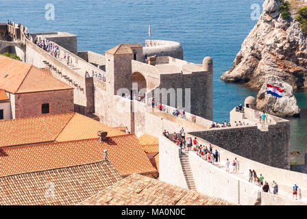 Menschen zu Fuß entlang der Spaziergang von der Altstadt von Dubrovnik, Kroatien, neben Terrakotta Dächer. Stockfoto