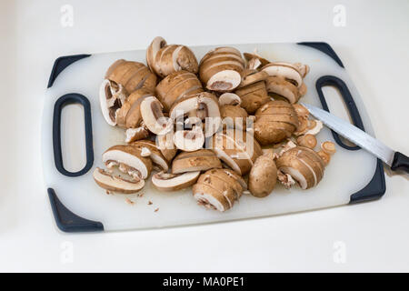 Ein Haufen von geschnittenen Kastanie Champignons (Agaricus bisporus) auf einem weißen Schneidebrett Stockfoto