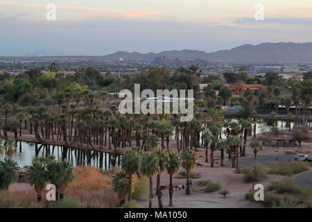 Phoenix, Arizona - März 21., 2018. Rote Felsen aus Sandstein mit Lagune und Palmen am Papago Park Phoenix Arizona am Sonnenuntergang Stockfoto