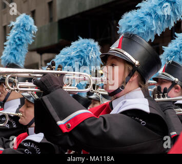 High School Mädchen spielen Trompete in der St. Patrick's Day Parade in New York, 2018. Marching Band, einheitliche, Hut mit blauen Federn. Close-up, Landschaft Stockfoto