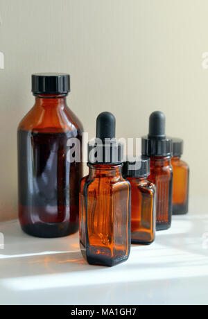 Verschiedene Größen von Braun/Gelb Arzneimittel, Flaschen, darunter auch einige mit Pipetten. Stockfoto