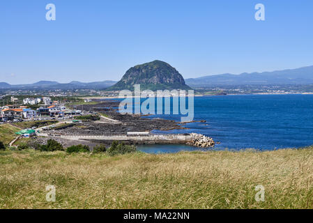 Landschaft von Sagye-ri Dorf und der südwestlichen Küste der Insel Jeju mit Sanbangsan und Hallasan Berg, von Olle trail Nr. 10 am Songaksan gesehen. Stockfoto