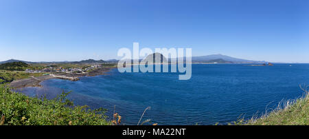 Landschaft von Sagye-ri Dorf und der südwestlichen Küste der Insel Jeju mit Sanbangsan und Hallasan Berg, von Olle trail Nr. 10 am Songaksan gesehen. Stockfoto