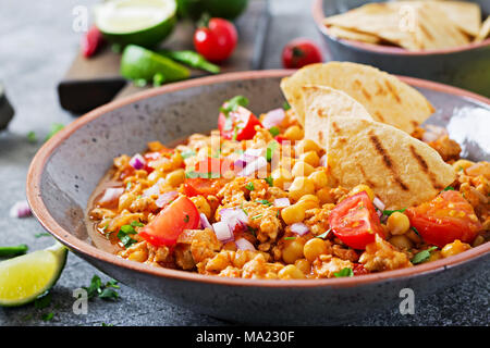 Chili con Carne der Türkei mit Kichererbsen, serviert mit Nachos. Chili mit Fleisch, Nachos, Kalk, Paprika. Mexikanische/Texas traditionelles Essen. Stockfoto