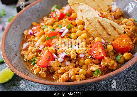 Chili con Carne der Türkei mit Kichererbsen, serviert mit Nachos. Chili mit Fleisch, Nachos, Kalk, Paprika. Mexikanische/Texas traditionelles Essen. Stockfoto