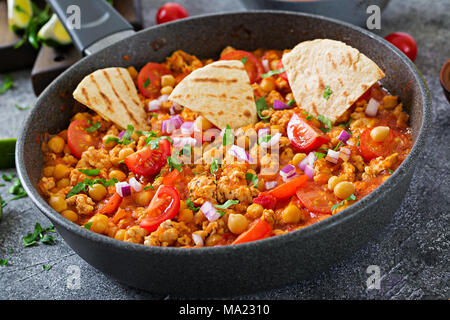 Chili con Carne der Türkei mit Kichererbsen, serviert mit Nachos. Chili mit Fleisch, Nachos, Kalk, Paprika. Mexikanische/Texas traditionelles Essen. Stockfoto