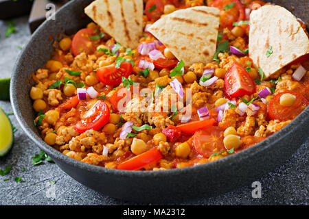 Chili con Carne der Türkei mit Kichererbsen, serviert mit Nachos. Chili mit Fleisch, Nachos, Kalk, Paprika. Mexikanische/Texas traditionelles Essen. Stockfoto