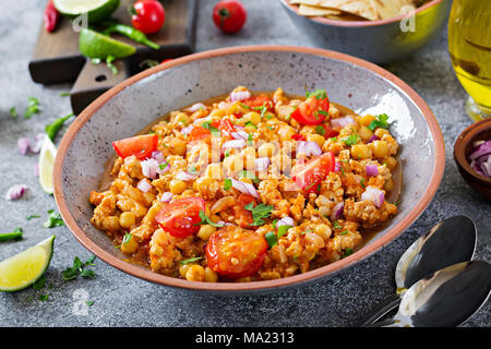 Chili con Carne der Türkei mit Kichererbsen, serviert mit Nachos. Chili mit Fleisch, Nachos, Kalk, Paprika. Mexikanische/Texas traditionelles Essen. Stockfoto