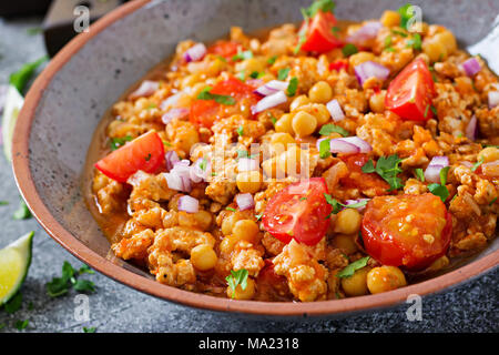 Chili con Carne der Türkei mit Kichererbsen, serviert mit Nachos. Chili mit Fleisch, Nachos, Kalk, Paprika. Mexikanische/Texas traditionelles Essen. Stockfoto