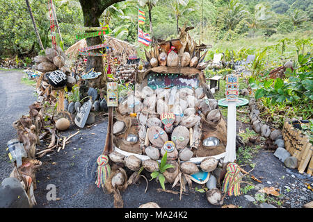 Eine Kokosnuss und Obst stehen in der Nähe von Kipahulu auf der Rückseite Strasse nach Hana, Maui, Hawaii. Stockfoto