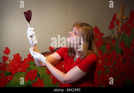 Leitender Kurator Elaine Edwards hält eine seltene Poppy aus den 1930er Jahren, die vor einem Auto, die Teil der Mohn Ausstellung im National War Museum in Edinburgh Castle das hundertjährige Jubiläum des Ende des Ersten Weltkrieges und die Geschichte und Bedeutung des Mohn als Symbol der Erinnerung zu markieren Markieren gebunden gewesen wäre. Stockfoto