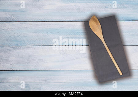 Holzlöffel und Küchentuch auf hellblau Boards. Stockfoto