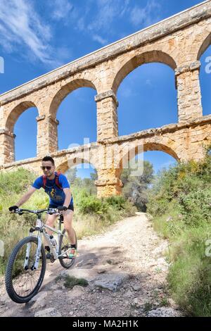 Ein Mountainbiker an der Wasserleitung in Katalonien, Spanien Stockfoto