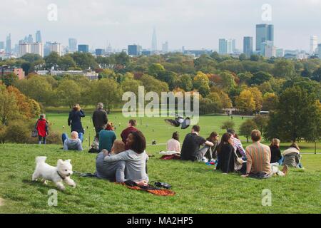 Menschen mit Picknicks im Park auf der Primrose Hill, London, England Stockfoto