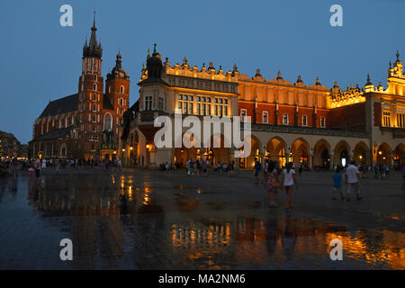 Niedrigen winkel Nacht Blick auf den Marktplatz mit Rathaus und Kirche Unserer Lieben Frau in den Himmel (St. Maria Kirche) nach dem Regen in Krakau, Polen Stockfoto