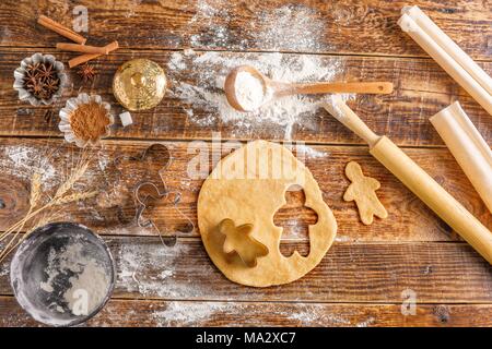 Den Teig auf einem Holztisch für Kekse rollte in der Form von kleinen Männer. Still-life auf einem hölzernen Hintergrund. Blick von oben. Stockfoto