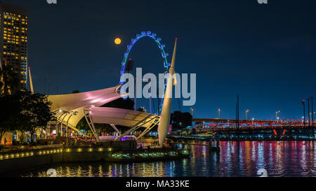 Volle Red Moon Rising in Singapur Stockfoto