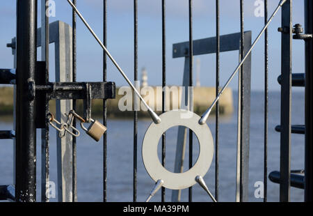 Mit einem Vorhängeschloss, verschraubt und mit einem Gatter versehener Eingang zum Pier am Seaham Harbour in County Durham Stockfoto