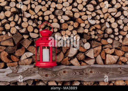 Rote Laterne vor Aufgehäuften brennholz Stockfoto