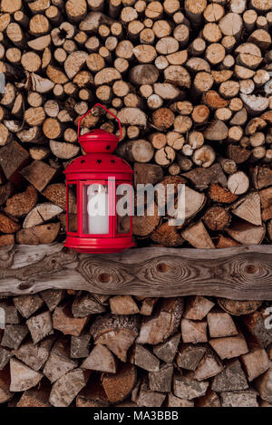 Rote Laterne vor Aufgehäuften brennholz Stockfoto