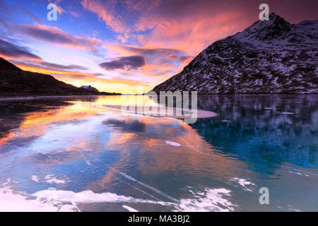 Atemberaubenden Sonnenaufgang auf dem gefrorenen Lago Bianco (Weißer See), Bernina, Engadin, Graubünden, Schweiz. Stockfoto